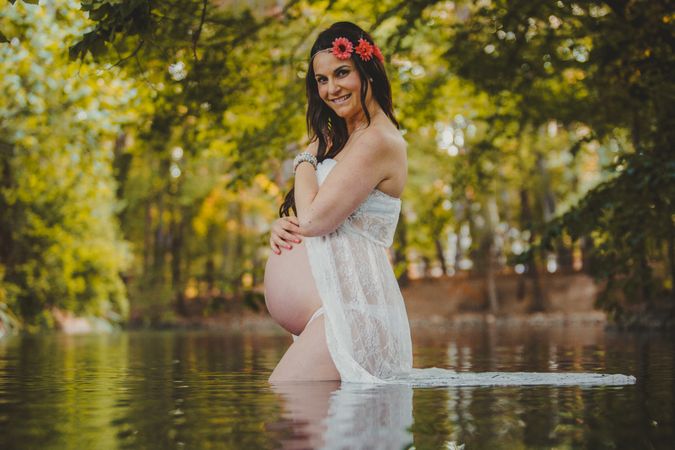 Pregnant woman standing in lake water