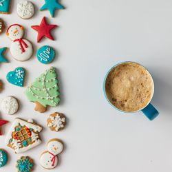Pattern of Christmas cookies and red berries with coffee cup