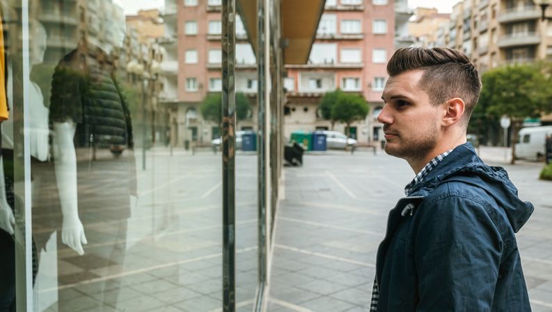 Man looking at the showcase of a store