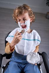 Boy shaving in a barbershop
