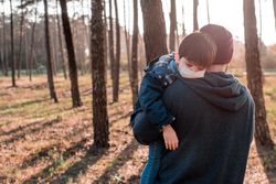 Man holding son with facemask