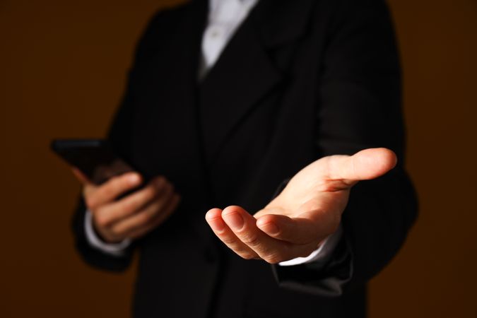 A man in a suit holds a smartphone