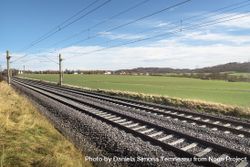 Railroad tracks through green meadow 5pQry4