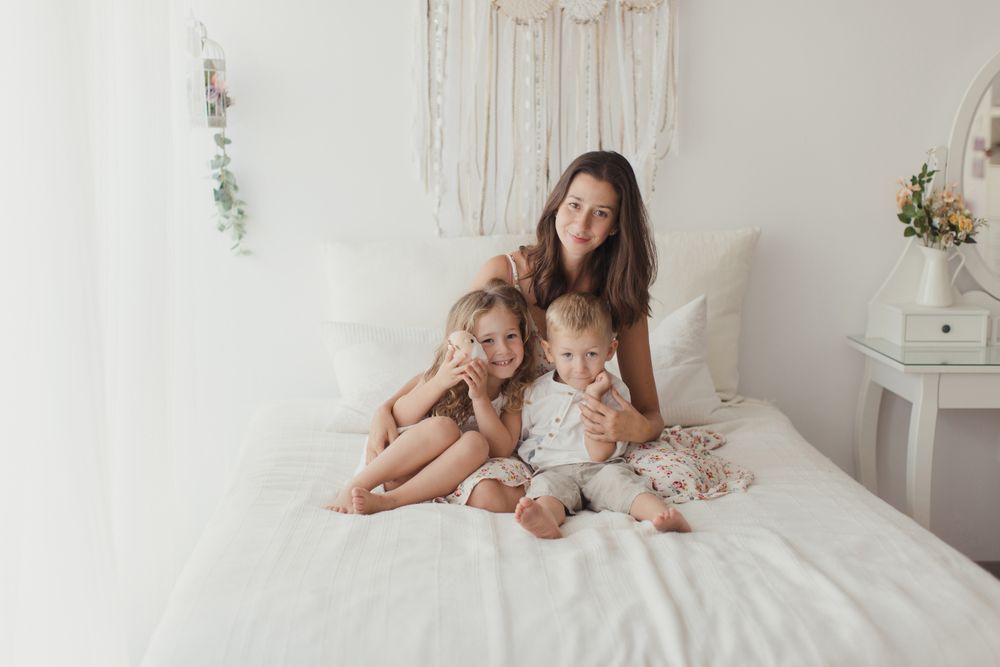 Content young mother with little kids at bedroom