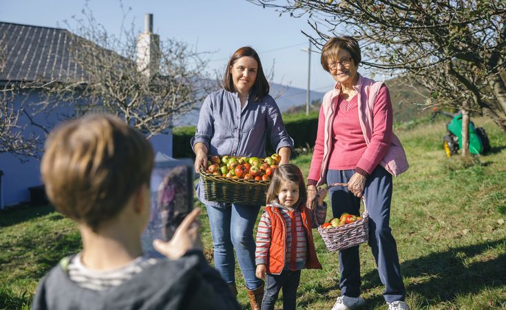 Family with apples in basket posing for photo