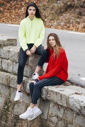 Women in sweaters sitting near road