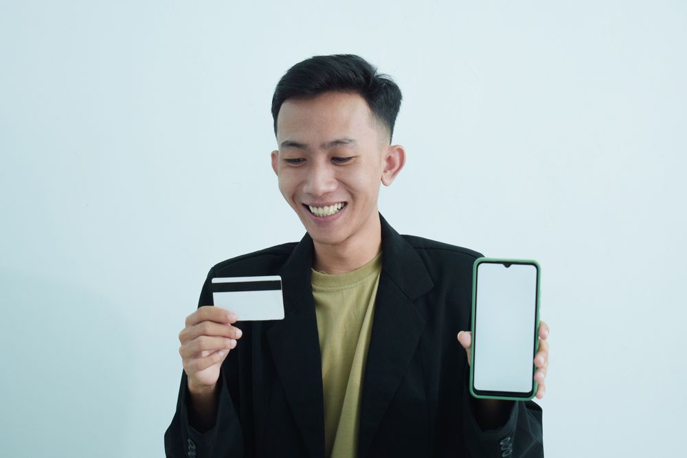 Businessman wear suit with t-shirt holding blank credit card in studio shoot
