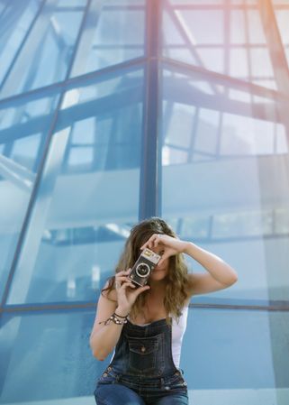 Creative woman taking photo on camera in sunny day