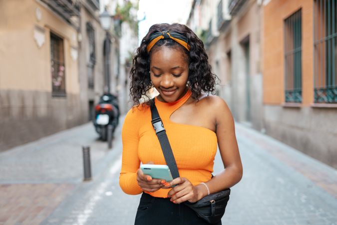 Portrait of a young Black woman using smartphone in the street