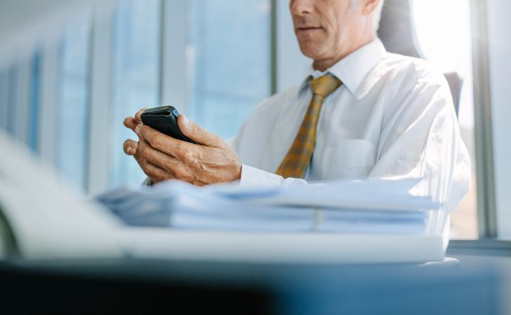 Business man using mobile phone in office