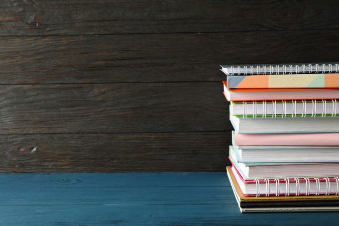 Composition with copybooks on wood table against dark background