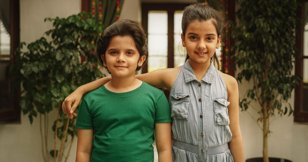 Portrait of Two Little Cute Indian Kids Posing Together in Their Home.