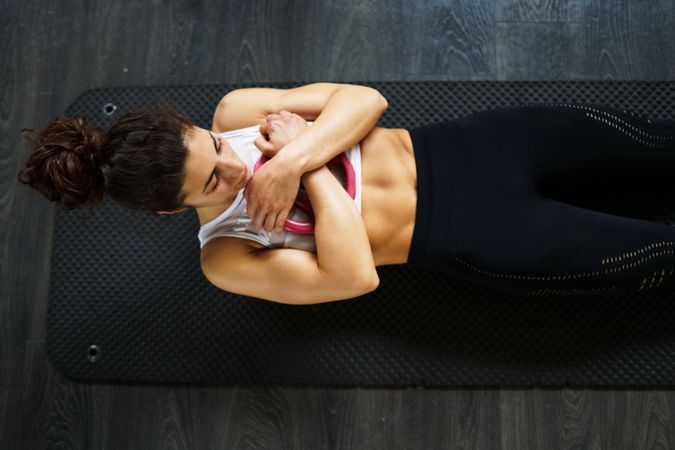 Fit woman doing sit ups with arms crossed over chest
