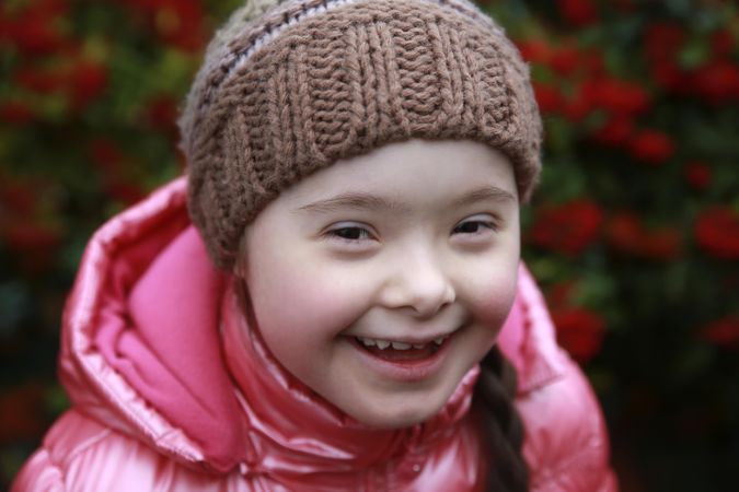Close up of smiling child wearing beanie and winter jacket