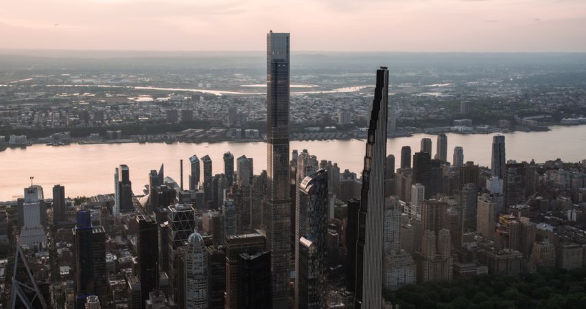 New York City Aerial Evening Cityscape with Stunning Manhattan Landmarks, Skyscrapers and Residential Buildings. Long Wide Angle Panoramic Helicopter View of a Popular Travel Destination