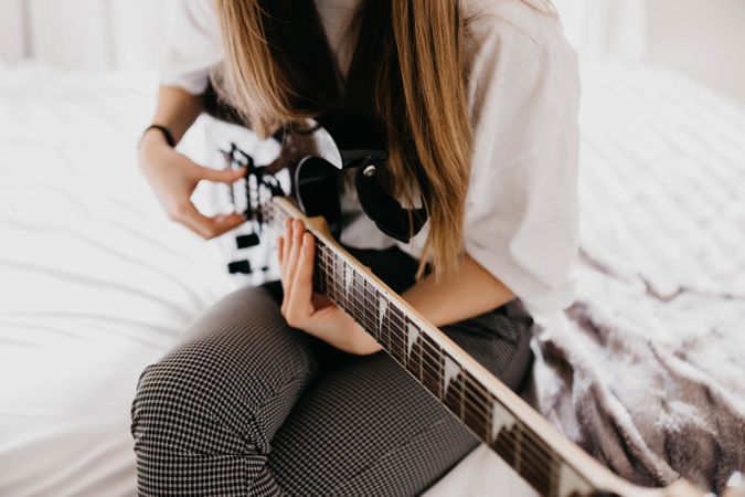 Young brunette woman playing guitar
