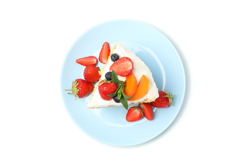 Plate with berry cream cake isolated on plain background