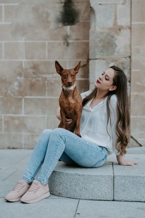 Woman with purebred dog on stone porch
