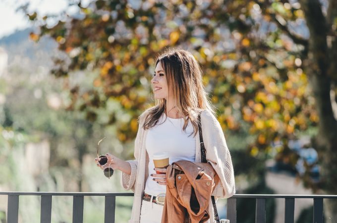 thoughtful woman leaning on handhold and looking along