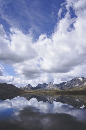 Cloudy sky over calm lake and mountains