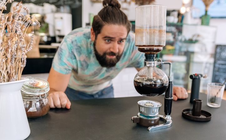 Barista skillfully brewing specialty coffee with Japanese siphon coffee maker
