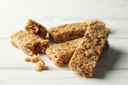 Tasty granola bars on wooden background