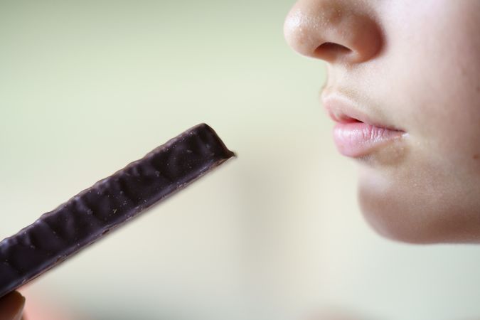Anonymous teenage girl about to eat cocolate bar