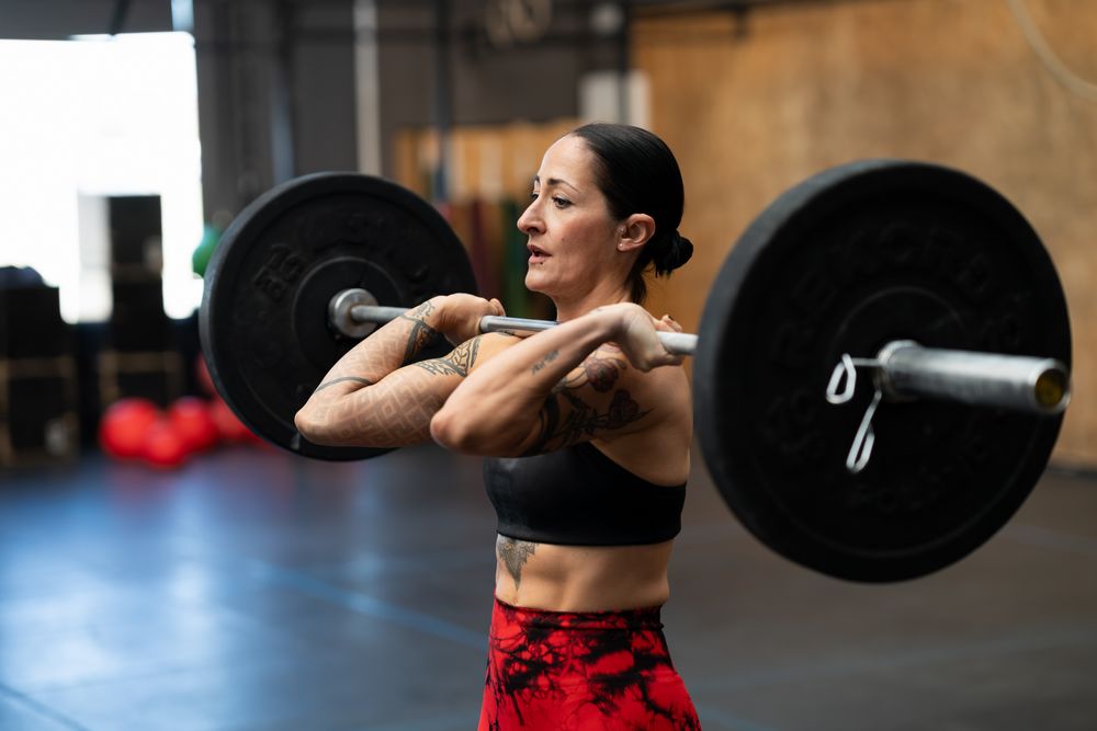 Strong concentrated woman lifting weights in a gym
