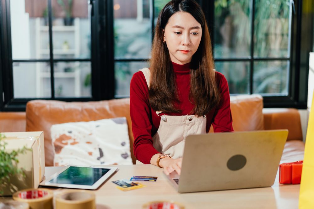 Asian woman working on her laptop at home
