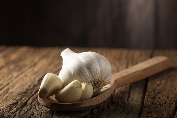 Garlic bulb and garlic cloves on the wooden table.