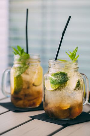 two Mojitos in mason jar on wooden table