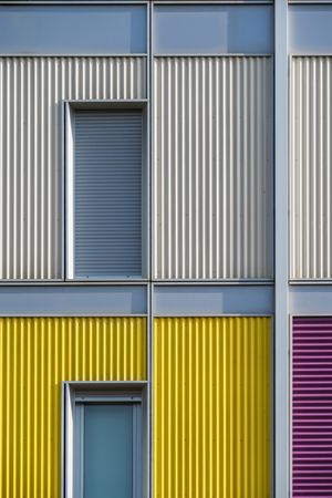 Facade of modern multicolored building with narrow windows