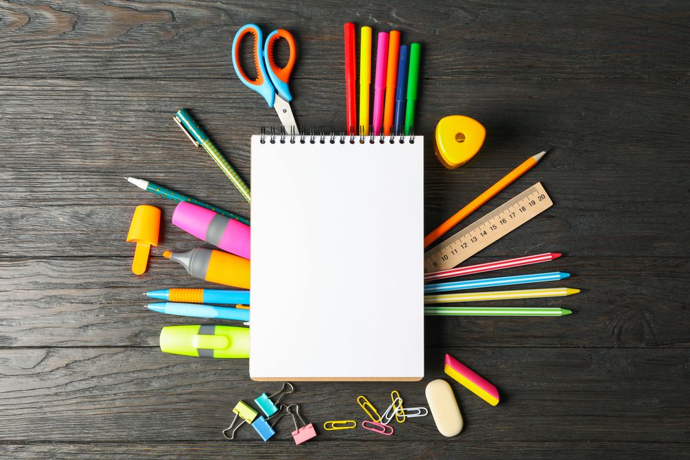 Flat lay composition with school supplies on wooden background, space for text