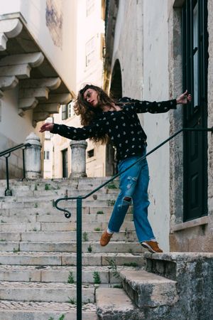 Casual woman dancing on old city street