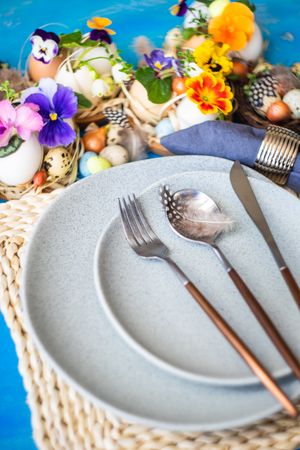 Easter table setting with grey plate and colorful flowers