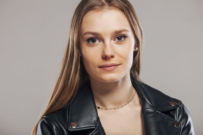 Blonde female with leather jacket posing in studio
