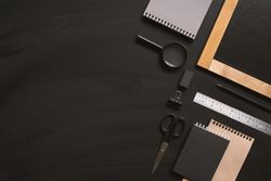 Writing board and stationary on dark background with copy space