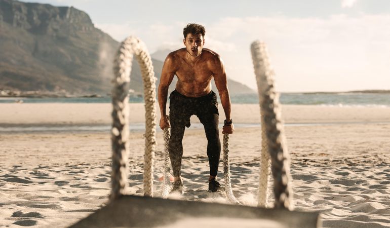 Fit male doing high intensity workout on the beach