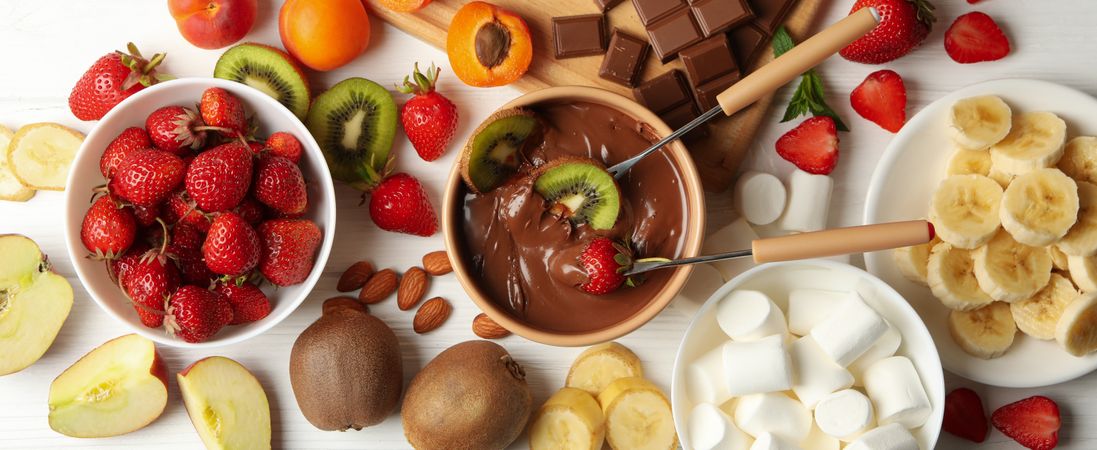Composition with ingredients for chocolate fondue on wooden background. Cooking fondue
