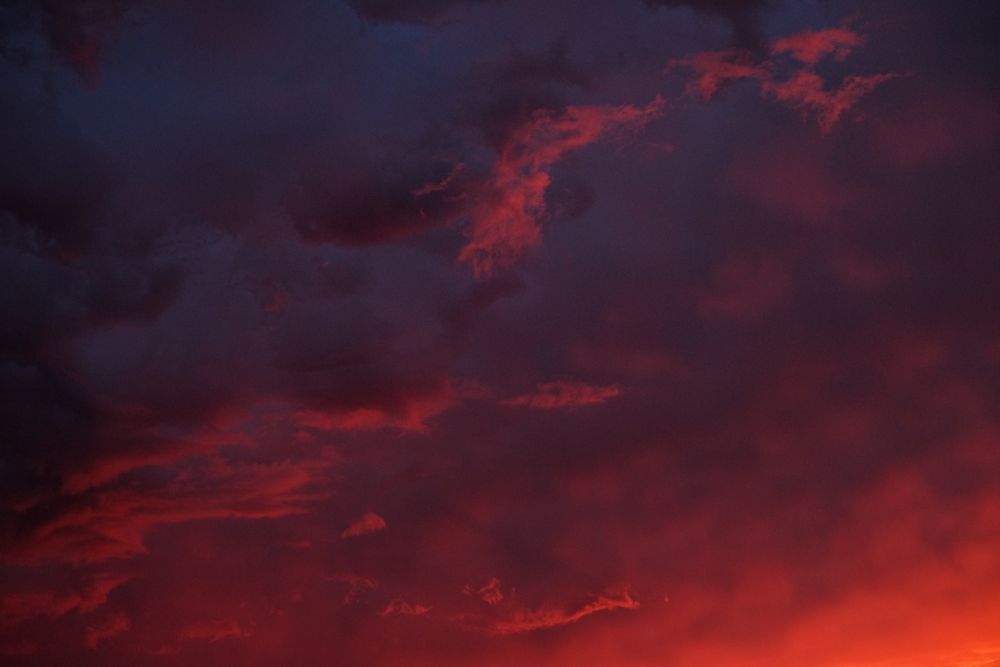 Bright red clouds in a blue sky at dawn