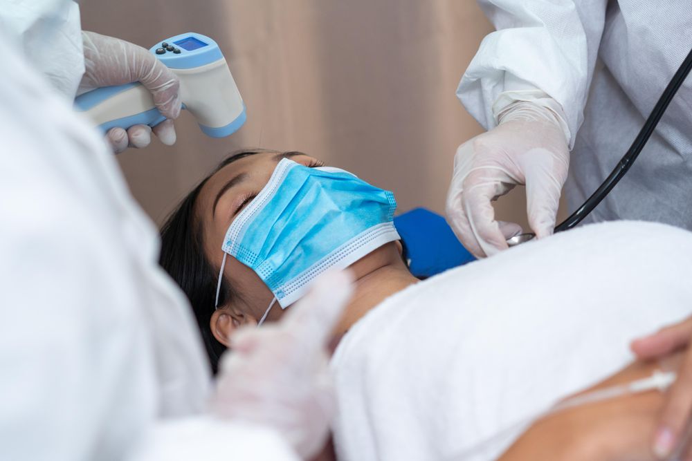 Doctor scanning temperature of female patient with thermometer