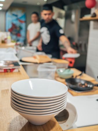 Bowls pile and kitchen staff in restaurant