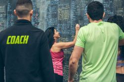 Athlete woman writing down results on the gym board