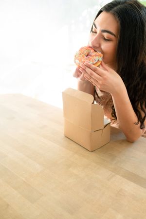 Happy woman in sundresses with box of glazed desserts