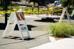 Caution sign with signal tape on closed playground