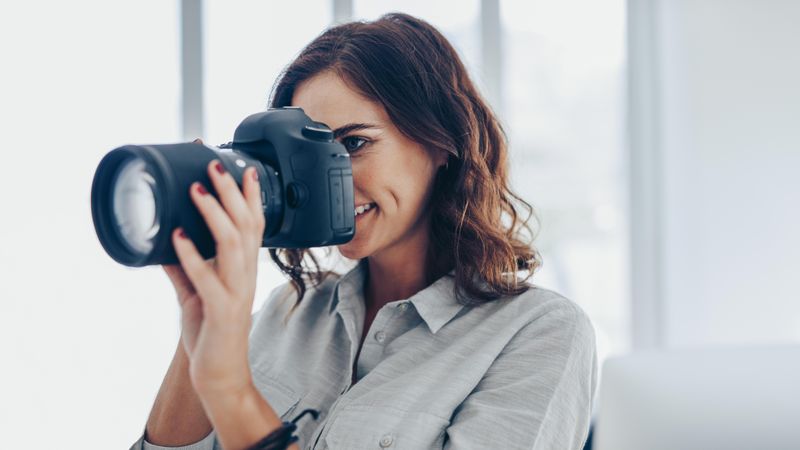 Woman with dslr camera photographing indoors
