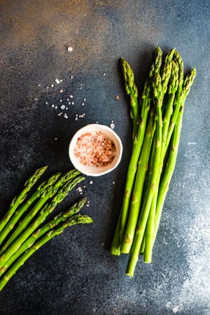 Raw asparagus on counter with Himalayan salt with copy space