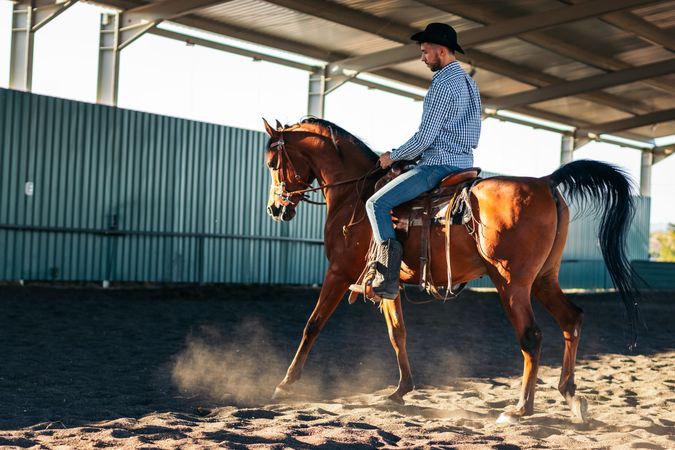 Man riding a horse in an equestrian center