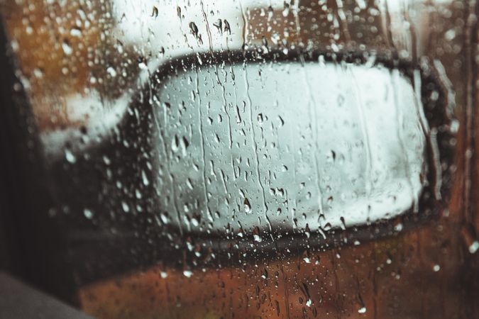 Wing mirror behind wet glass