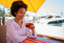 Woman with glass of beer at cafe on the harbor